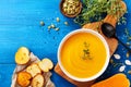 Diet autumn pumpkin or carrot cream soup in bowl served with seeds and crouton on blue rustic table top view Royalty Free Stock Photo