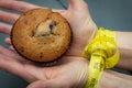 Diet, bondage and delayed gratification concept with woman hand reaching for a muffin while her hands are tied together with