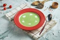 Diet broccoli cream soup with cream in a composition with ingredients on a gray background. Healthy cream soup green