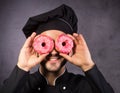 Close up portrait of happy cute chef cooker with sweet donuts