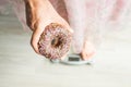 Diet Concept. Close-up of Woman`s feet On Weighing Scale With Donut. Concept of Sweets, Unhealthy Junk Food and obesity. Royalty Free Stock Photo