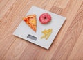 Diet. The concept of junk food on weight. Healthy Lifestyle. Wooden background.