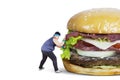 Overweight man pushing big burger Royalty Free Stock Photo