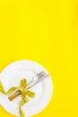 Diet concept with plate, flatware and measuring tape for weight loss on yellow background top view mock up