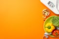 Diet concept. Top view photo of scales tape measure plate with pepper cabbage tomato and nuts on isolated orange background with Royalty Free Stock Photo