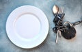 Diet concept. White empty plate with spoon and fork coiled with chain