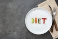 Diet concept. White plate with word - diet - composed of slices of different fruits and vegetables with knife and fork. Copy space Royalty Free Stock Photo