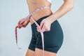 Diet concept, woman measuring her waist with a measure tape Royalty Free Stock Photo