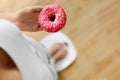 Diet Concept. Woman On Scale Holding Donut. Weight Loss. Dieting Royalty Free Stock Photo