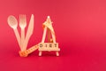 Diet concept - wooden cutlery, yellow measuring tape and word DIET on wooden bricks, on red burgundy background with copyspace.