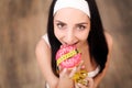 Diet Concept. Young Woman Measuring Body Weight On Weighing Scale While Holding Glazed Donut With Sprinkles. Sweets Are Unhealthy Royalty Free Stock Photo