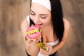 Diet Concept. Young Woman Measuring Body Weight On Weighing Scale While Holding Glazed Donut With Sprinkles. Sweets Are Unhealthy Royalty Free Stock Photo