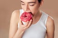 Diet Concept. Young Woman Measuring Body Weight On Weighing Scale While Holding Glazed Donut With Sprinkles. Sweets Are Unhealthy Royalty Free Stock Photo