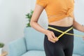 Diet and dieting. Beauty slim female body use tape measure. Woman in exercise clothes achieves weight loss goal for healthy life, Royalty Free Stock Photo