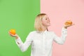 Diet. Dieting concept. Healthy Food. Beautiful Young Woman choosing between fruits and unhelathy fast food Royalty Free Stock Photo