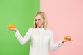 Diet. Dieting concept. Healthy Food. Beautiful Young Woman choosing between fruits and unhelathy fast food Royalty Free Stock Photo