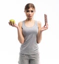 Diet. Dieting concept. Healthy Food. Beautiful Young Woman choosing between Healthy and Unhealthy Food.Fruits or Sweets Royalty Free Stock Photo