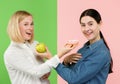 Diet. Dieting concept. Healthy Food. Beautiful Young Women choosing between fruits and unhelathy cake Royalty Free Stock Photo