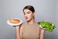 Diet. Dieting concept. Healthy Food. Lovely young woman choosing between sandwich and vegetable. Weight loss Royalty Free Stock Photo