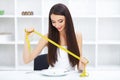 Diet. Eating disorder. Girl is holding a plate and trying to put Royalty Free Stock Photo