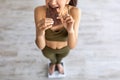 Diet failure, cheat meal concept. Above view of Indian woman eating chocolate while standing on scales