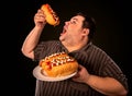 Fat man eating fast food hot dog. Breakfast for overweight person. Royalty Free Stock Photo