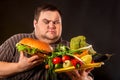 Diet fat man makes choice between healthy and unhealthy food. Royalty Free Stock Photo