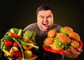 Diet fat man makes choice between healthy and unhealthy food. Royalty Free Stock Photo