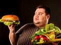 Diet fat man makes choice between healthy and unhealthy food. Royalty Free Stock Photo