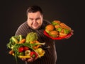 Diet fat man makes choice between healthy and unhealthy food. Royalty Free Stock Photo