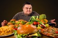 Diet fat man makes choice between healthy and unhealthy food. Royalty Free Stock Photo