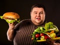 Diet fat man makes choice between healthy and unhealthy food. Royalty Free Stock Photo