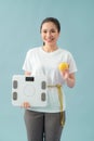 Diet and fitness concept - beautiful sporty woman with scale, yellow apple and measuring tape Royalty Free Stock Photo