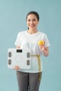 Diet and fitness concept - beautiful sporty woman with scale, yellow apple and measuring tape Royalty Free Stock Photo