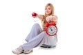 Woman holding apple, measuring tape and clock