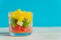 Diet Fresh tasty mix fruit salad in a glass jar on blue background. Chopped juicy oranges, kiwi and grapefruits Royalty Free Stock Photo