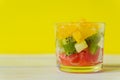 Diet Fresh tasty mix fruit salad in a glass jar on bright yellow background. Chopped juicy oranges, kiwi and grapefruits Royalty Free Stock Photo