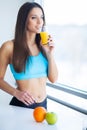 Diet. Happy smiling young woman drinking orange juice Royalty Free Stock Photo