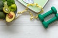 Diet and Healthy life loss weight Concept. Green apple and Weight scale measure tap with fresh vegetable and sport equipment for w