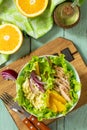 Diet menu. Healthy salad with chicken, egg pancakes, orange, green salad and dressing vinaigrette on wooden table. Royalty Free Stock Photo