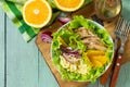 Diet menu. Healthy salad with chicken, egg pancakes, orange, green salad and dressing vinaigrette on wooden table. Royalty Free Stock Photo