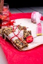 Diet muesli bars with detox apple cinnamon water and measuring tape on red pepper and wooden background Royalty Free Stock Photo