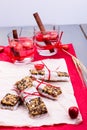 Diet muesli bars with detox apple cinnamon water on red pepper and wooden background. Royalty Free Stock Photo