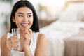 Happy Asian Woman Taking Pill And Holding Glass Of Water Royalty Free Stock Photo