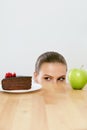 Diet And Nutrition. Woman Choosing Between Cake And Apple. Royalty Free Stock Photo