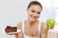 Diet And Nutrition. Woman Choosing Between Cake And Apple.