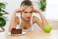 Diet And Nutrition. Woman Choosing Between Cake And Apple.