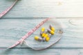 Diet Pills with measuring tape on  wooden background. Diet concept. Shallow Depth of field Royalty Free Stock Photo