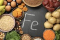Diet plan for anemia. Different products rich in iron and slate board with Ferrum symbol on table, flat lay. Space for text Royalty Free Stock Photo