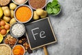 Diet plan for anemia. Different products rich in iron and small chalkboard with Ferrum symbol on grey table, flat lay. Space for Royalty Free Stock Photo